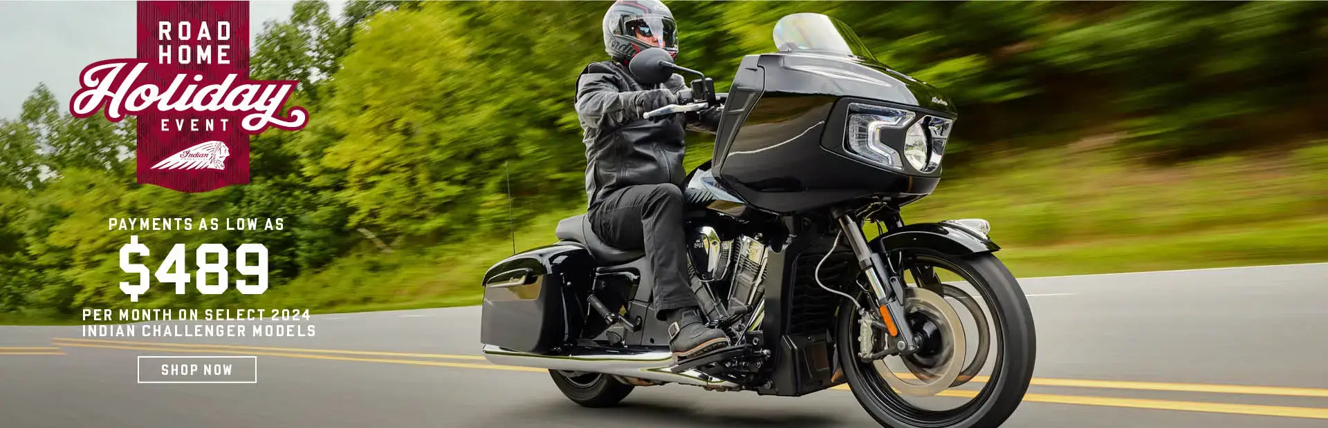 Indian Challenger riding down a road in a forest landscape. Promotional offer: Payments as low as $489 per month on Select 2024 Challenger models.