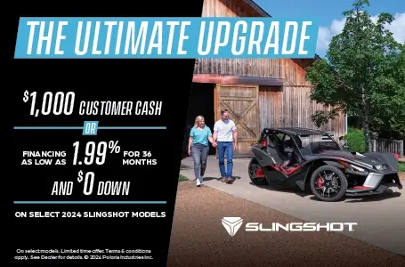 A man and women walking towards a dark gray Slingshot. Promotional Offer: $1000 customer cash or financing as low as 1.99% for 36 months and $0 down on select 2024 slingshot models.