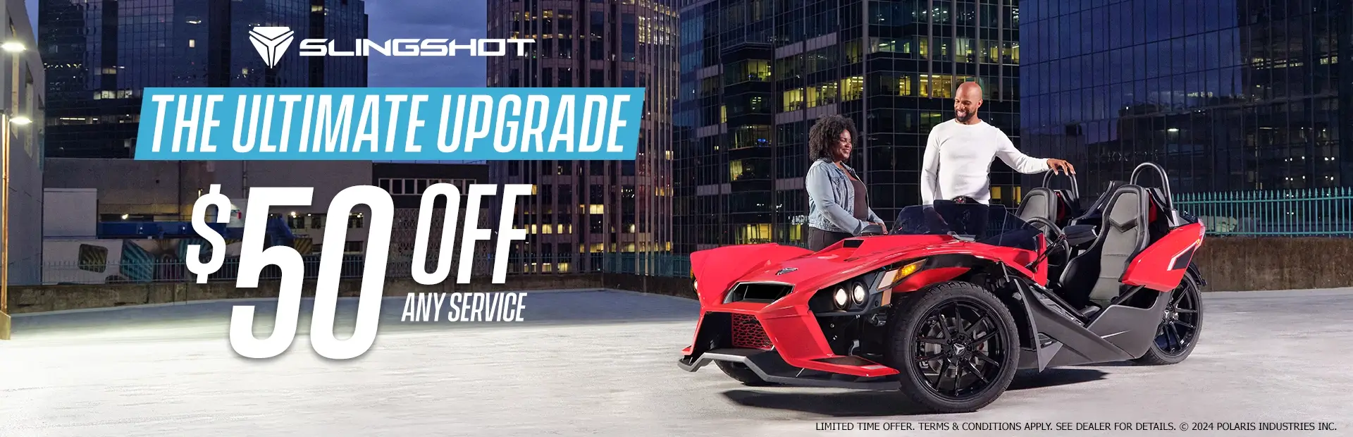 A man and a woman standing next to a red slingshot in an empty lot. Promotional Offer: The ultimate upgrade. $50 off any service.