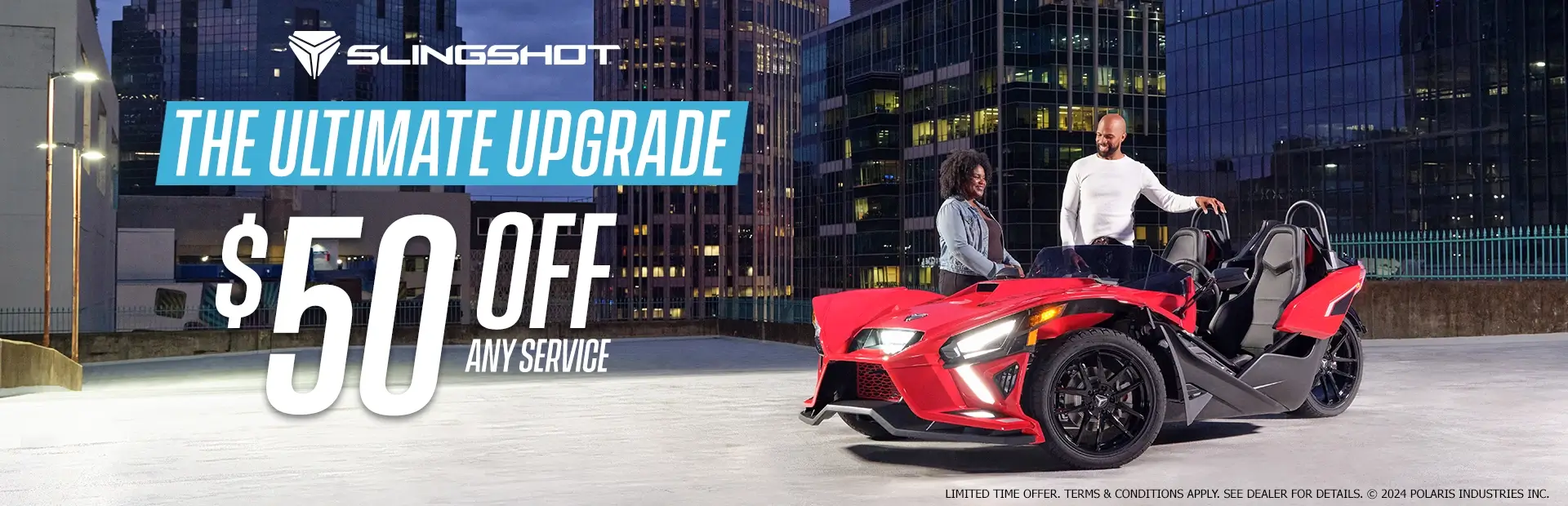 A man and a woman standing next to a red slingshot in an empty lot. Promotional Offer: The ultimate upgrade. $50 off any service.