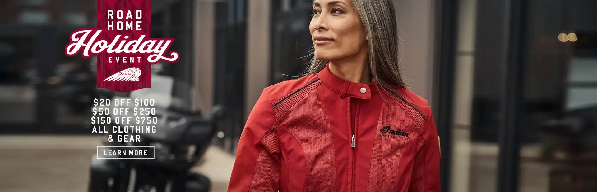 Female wearing new Indian Motorcycle Red Jacket. Promotional Offer: $20 off $100, $50 off $250, $150 off $750 all  clothing & gear.