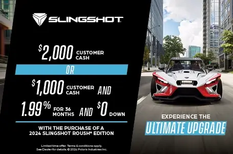 Slingshot Roush edition driving down the street. With a promotion of $2000 customer cash or $1000 customer cash and 1.99% for 36 months and $0 down with the purchase of a 2024 Slingshot Roush Edition.