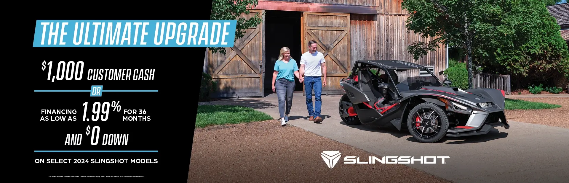 A man and women walking towards a dark gray Slingshot. Promotional Offer: $1000 customer cash or financing as low as 1.99% for 36 months and $0 down on select 2024 slingshot models.