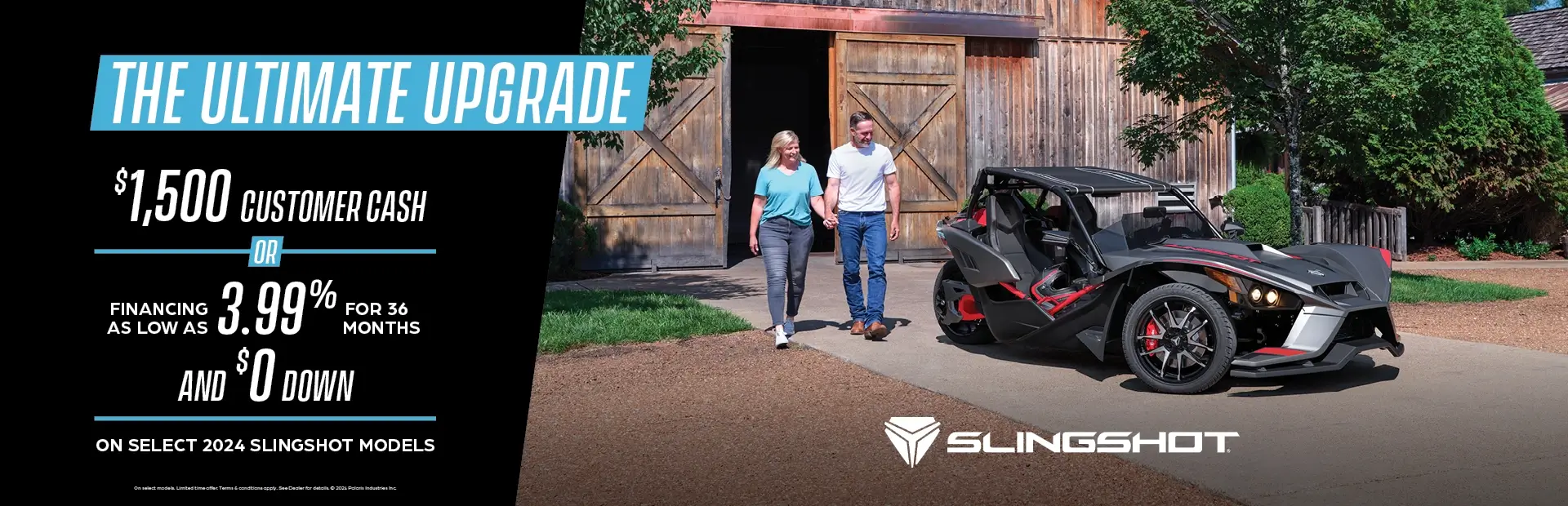 A man and women walking towards a dark gray Slingshot. Promotional Offer: $1500 customer cash or financing as low as 3.99% for 36 months and $0 down on select 2024 slingshot models.